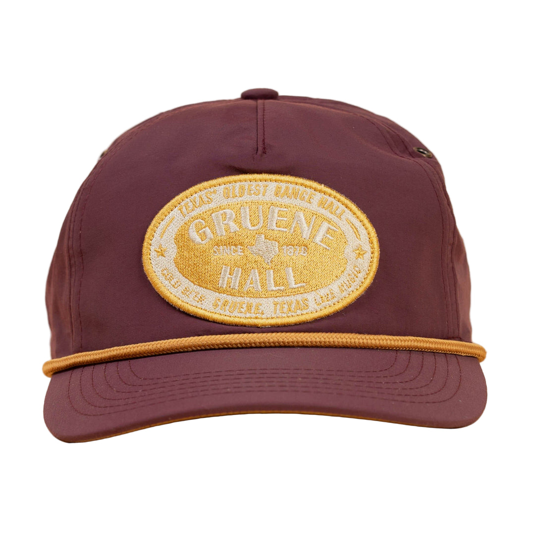 Purple cap with a yellow embroidered patch on a beige background