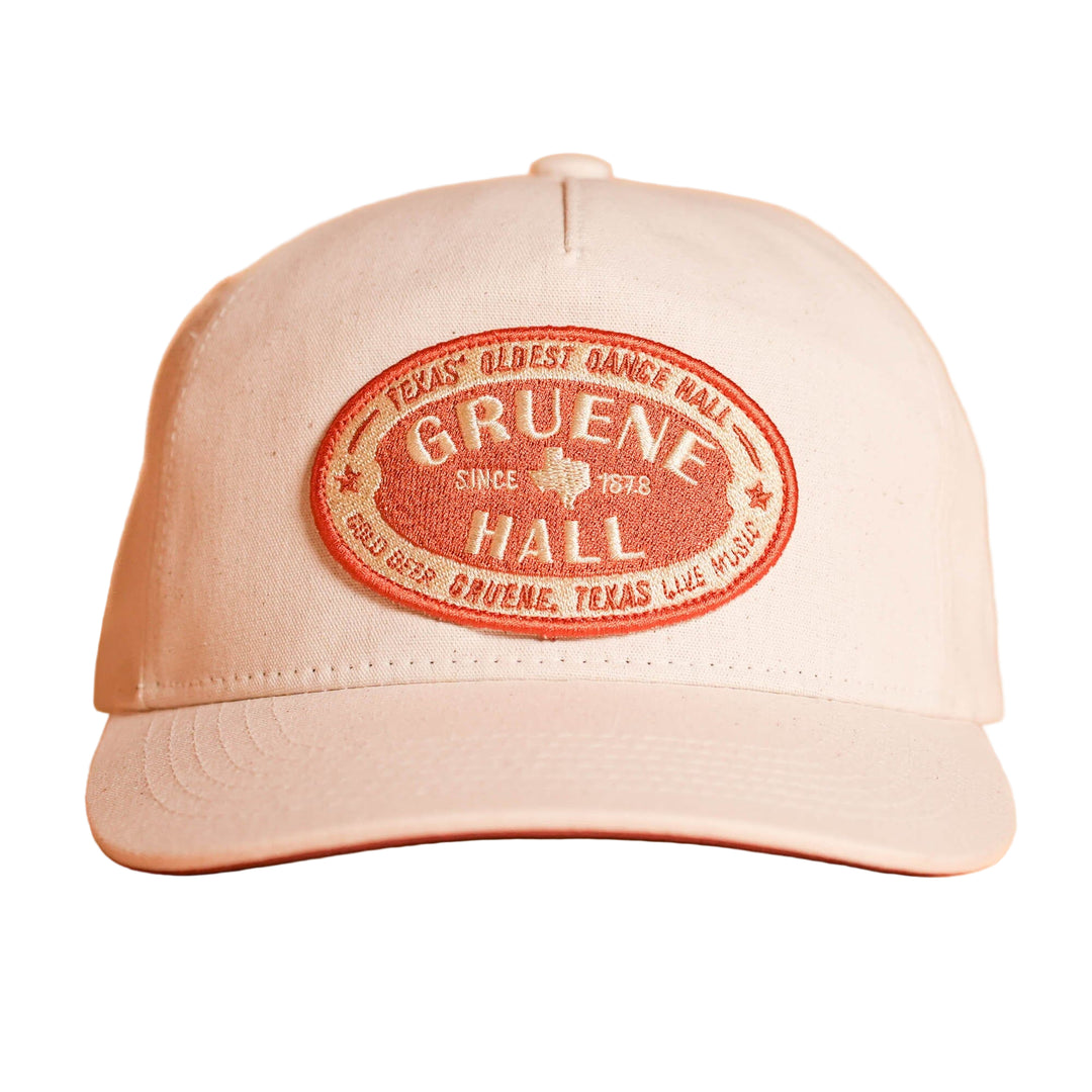 Beige cap with red 'Gruene Hall' logo on a peach background