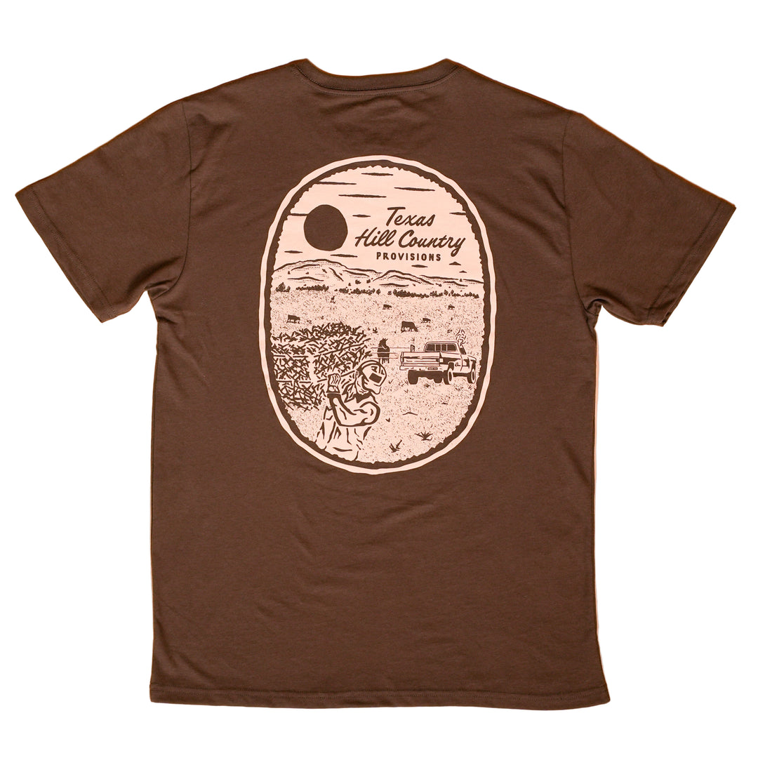 Brown t-shirt with a graphic design on the back against a peach background